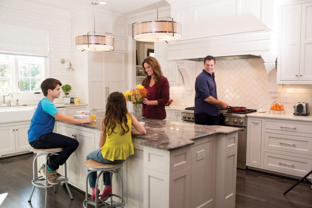 A happy family enjoys a meal together in their comfortable, climate-controlled home kitchen.